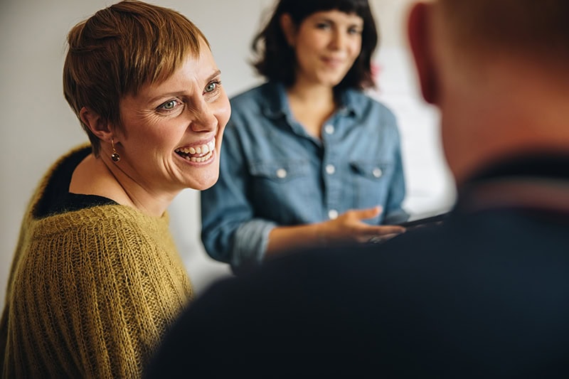 Tre kolleger deltager i en effektiv og engagerende arbejdsglæde-workshop.