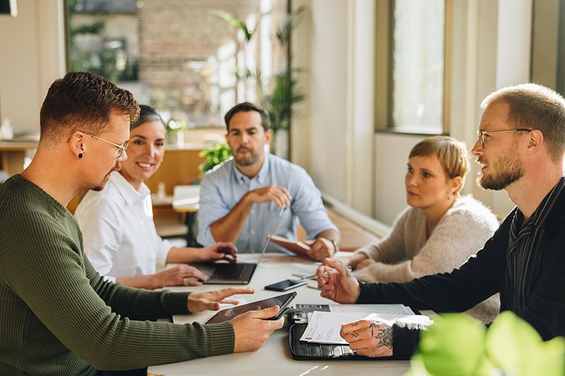 Kollegaer til et projektteam-workshop på arbejdspladsen med fokus på personprofiler og teamwork.